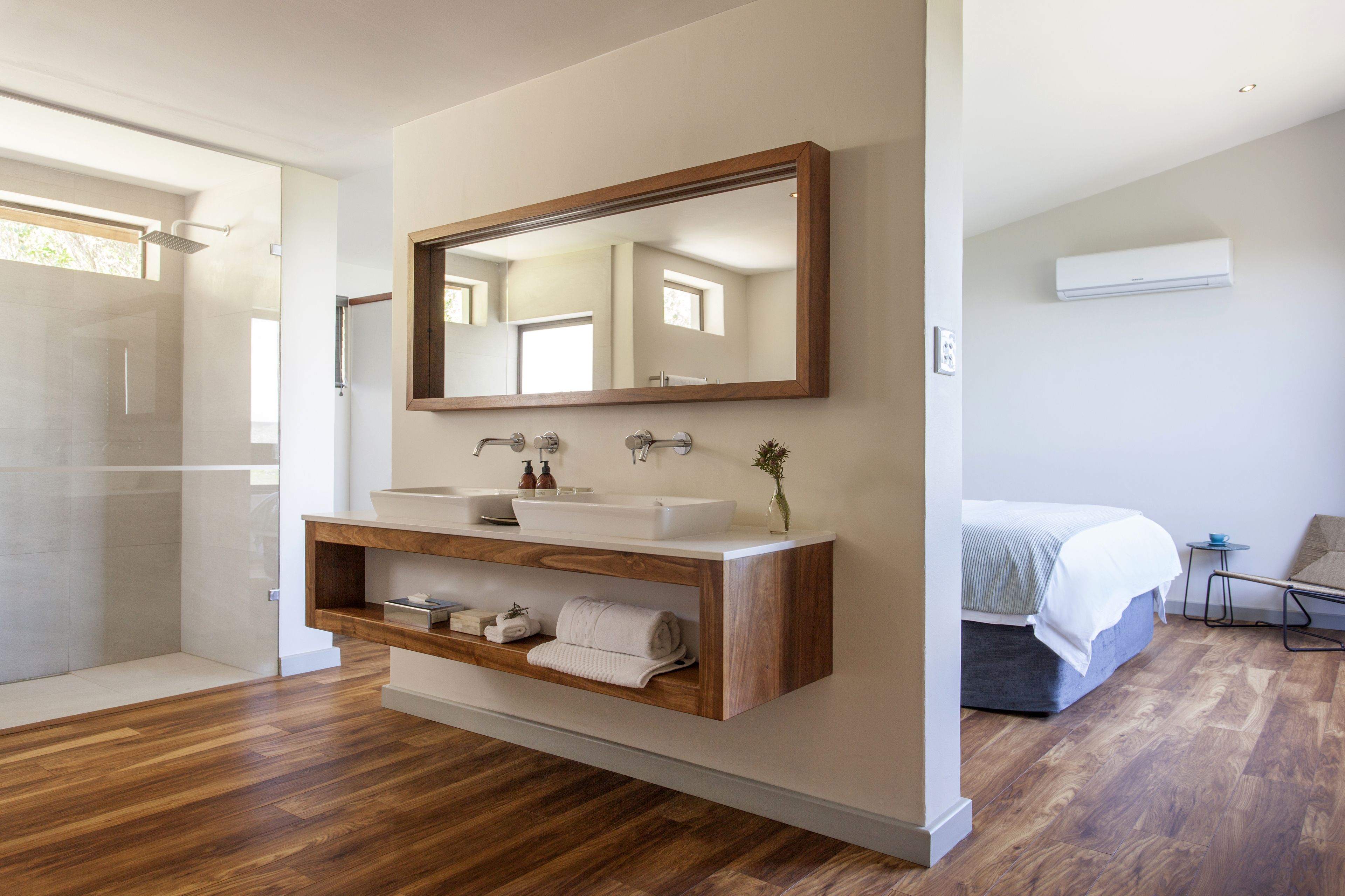 A modern bathroom with a freestanding sink, a mirror, and a shower area.