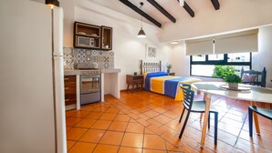 Een moderne keuken met een fornuis, oven en een eethoek met een tafel en stoelen.