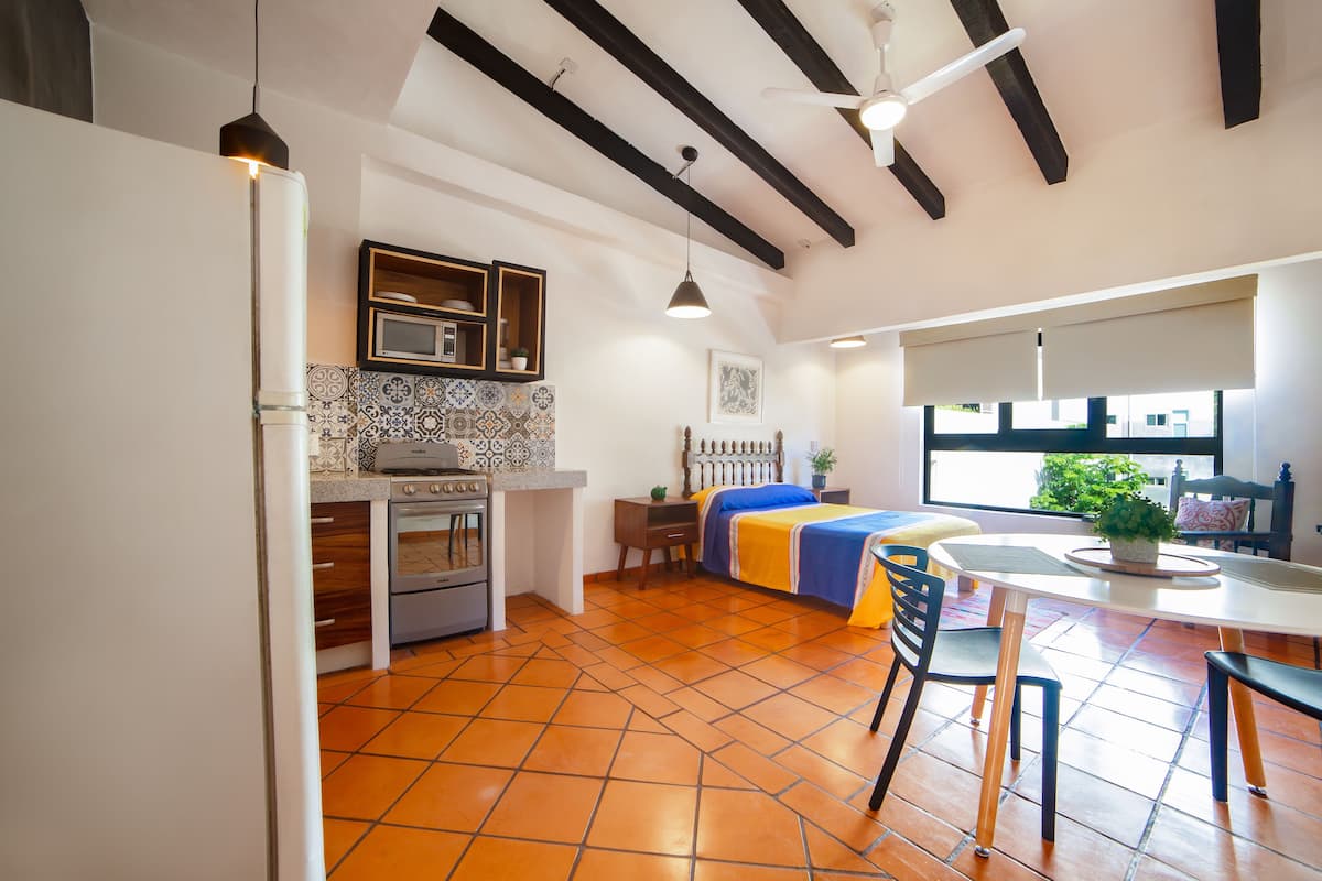 Een moderne keuken met een fornuis, oven en een eethoek met een tafel en stoelen.