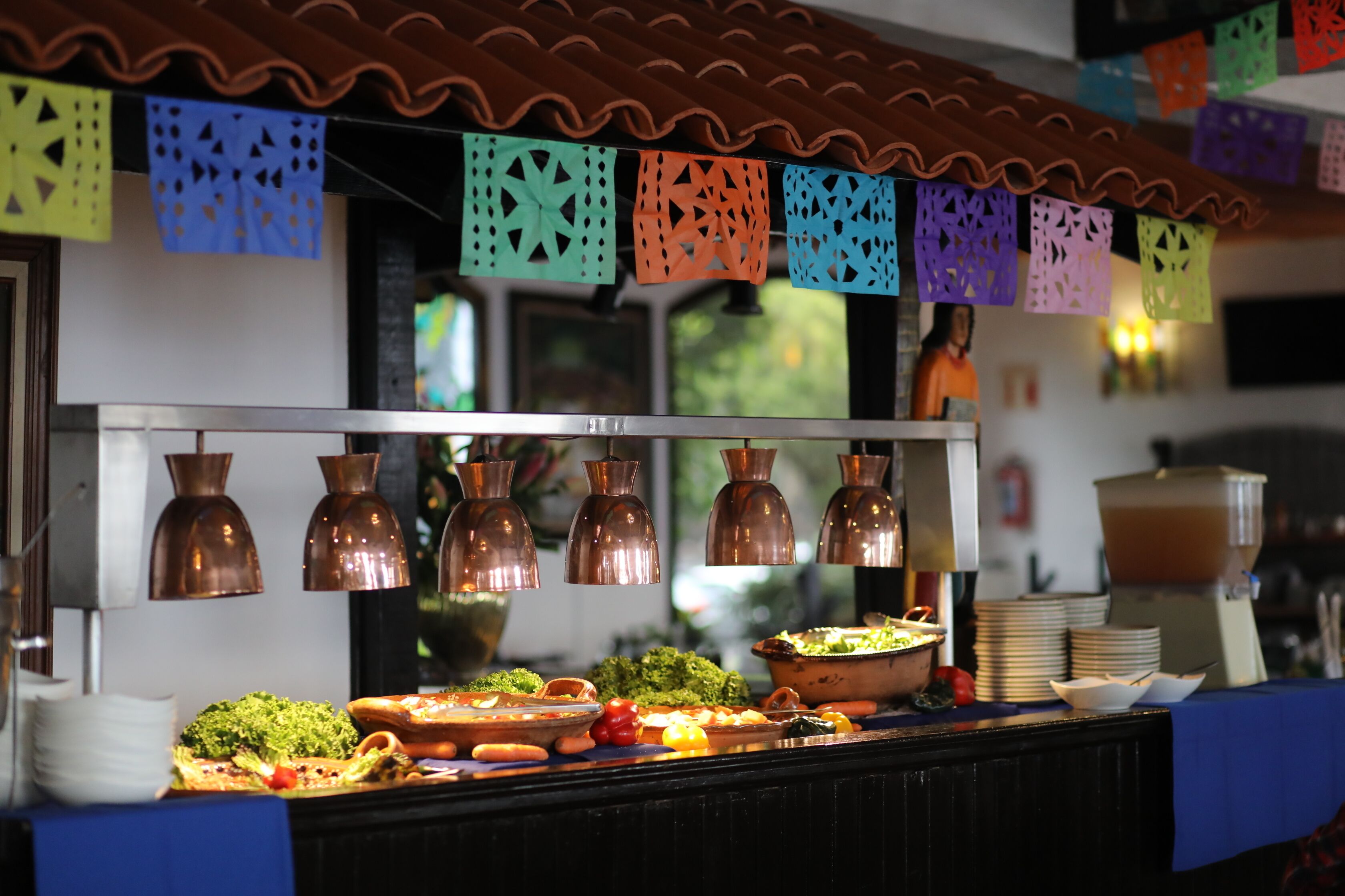 Montaje de bufé con diversos platos y un techo decorativo.