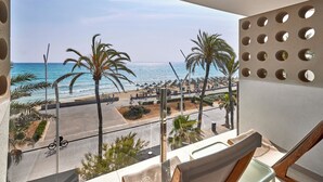 A balcony with a view of the beach, palm trees, and a clear sky. - Universal Hotel Neptuno - Adults Only (Palma de Mallorca)