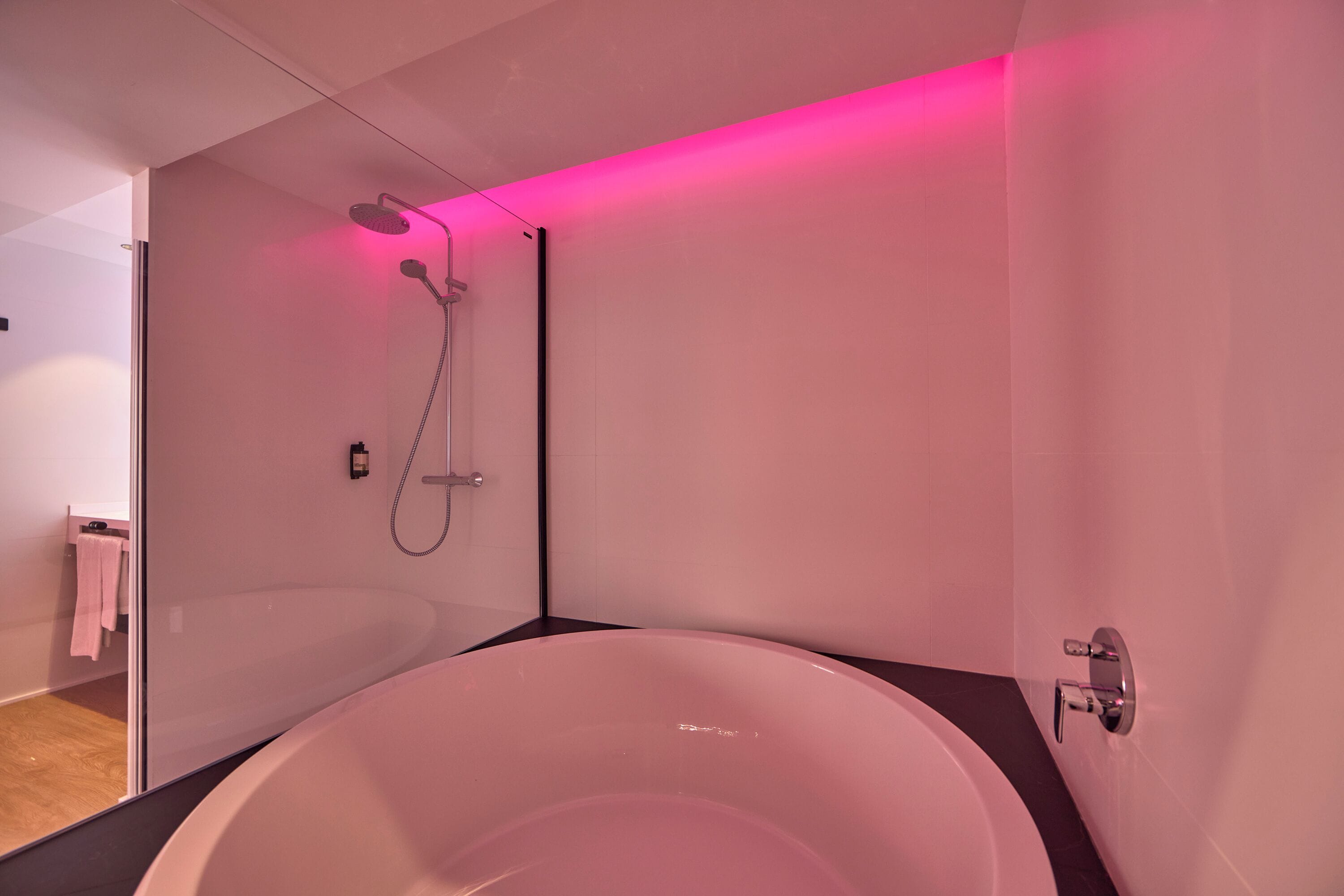 A modern bathroom with a freestanding bathtub, a showerhead, and a towel rack.