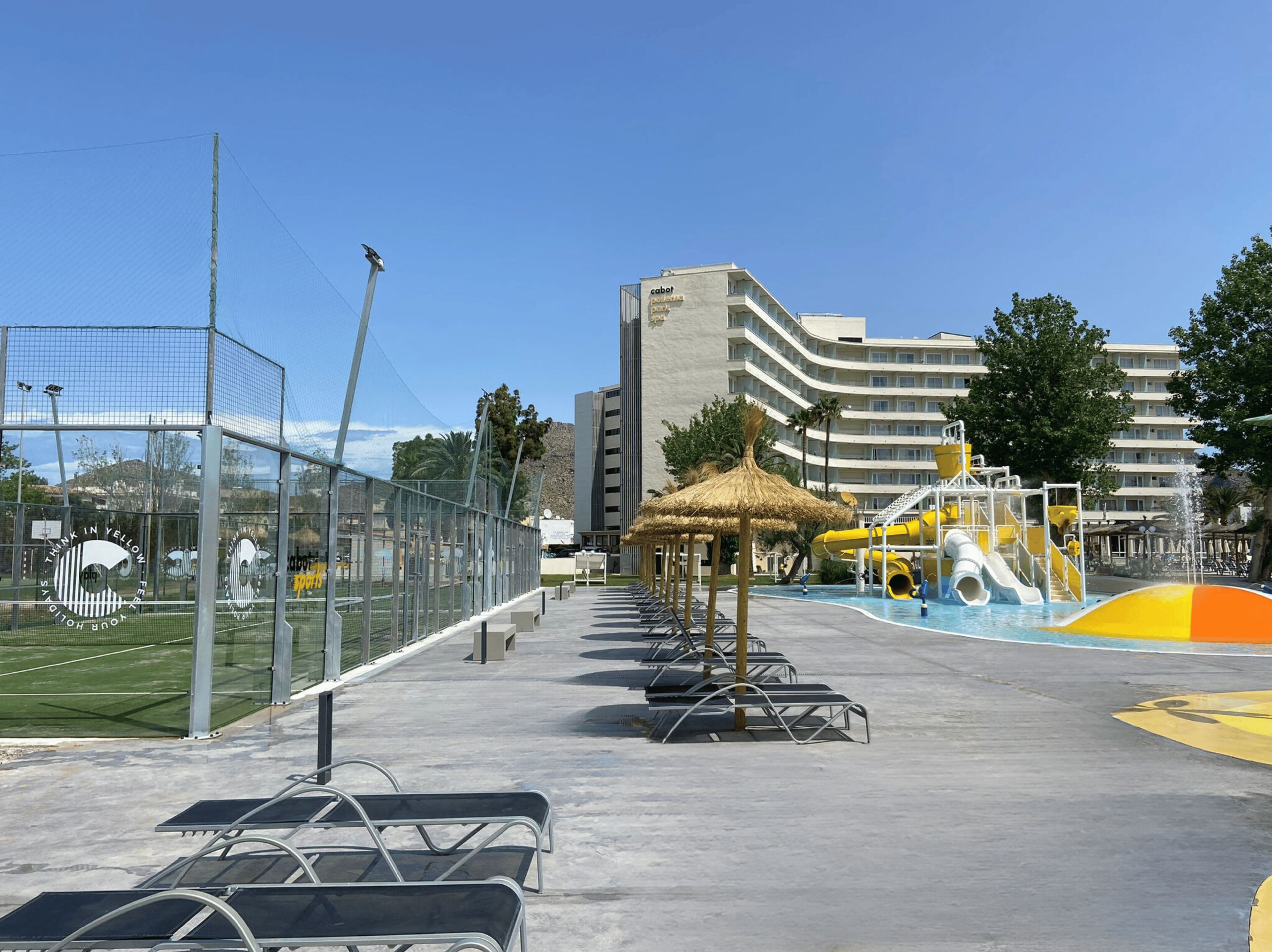 A sports court with a net, a water park with slides, and a building with balconies.