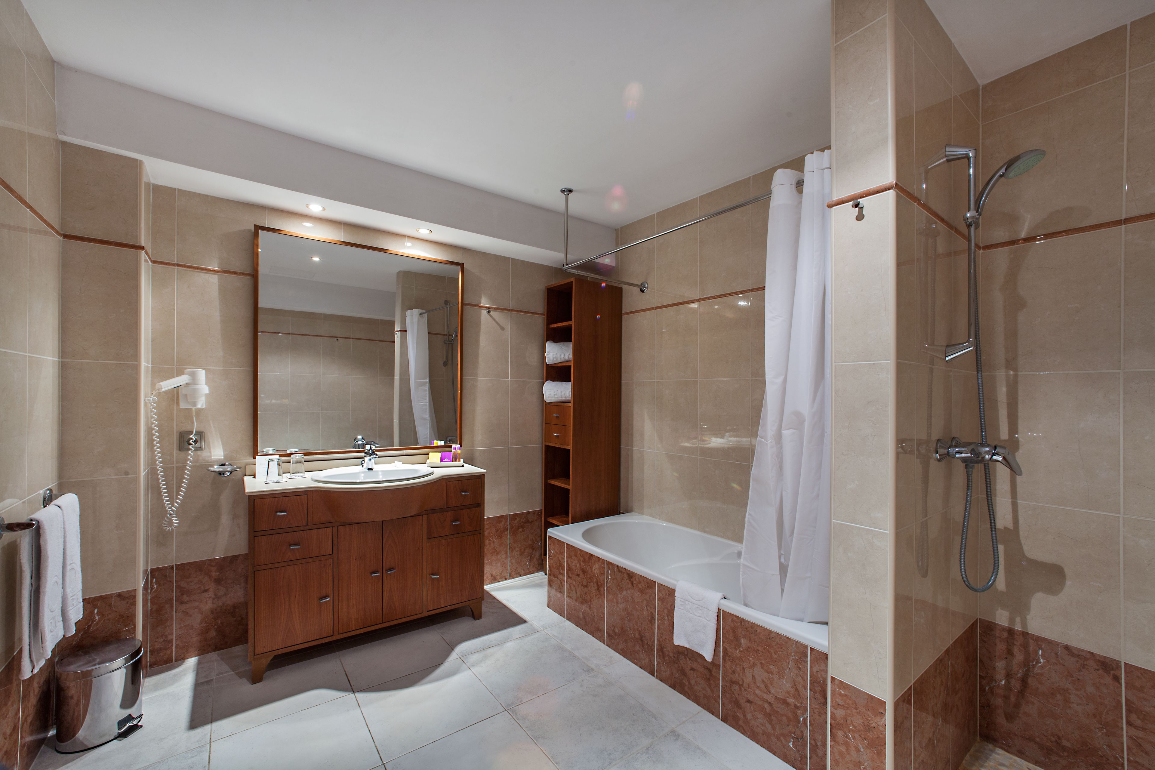 A modern bathroom with a large mirror, a vanity with a sink, a bathtub, and a shower.