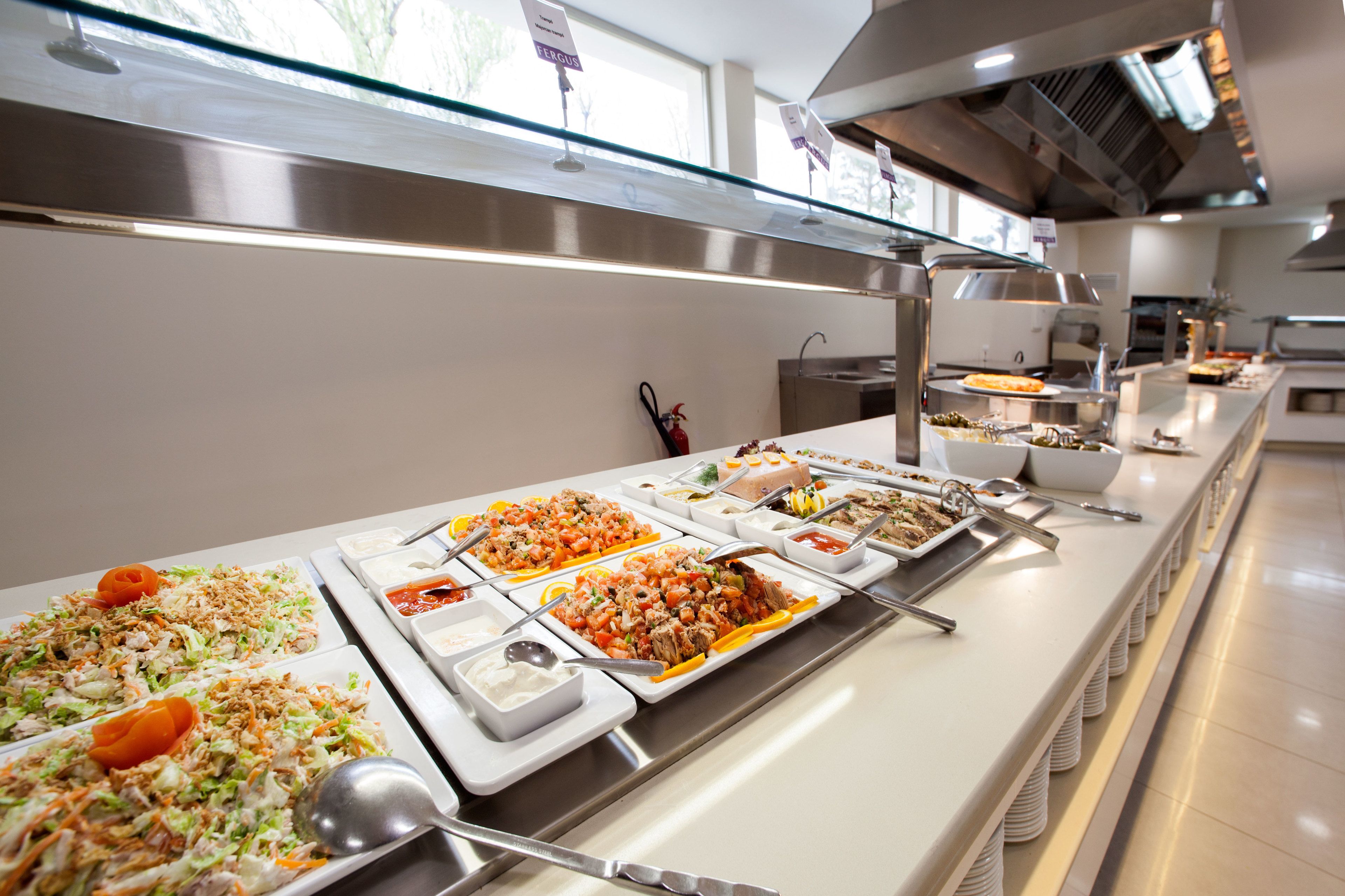 A buffet with various dishes and serving utensils.