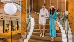 A modern interior with a staircase, wooden paneling, and a large spherical light fixture. - Cabot Pollensa Park Spa - Family Resort (Pollenca)