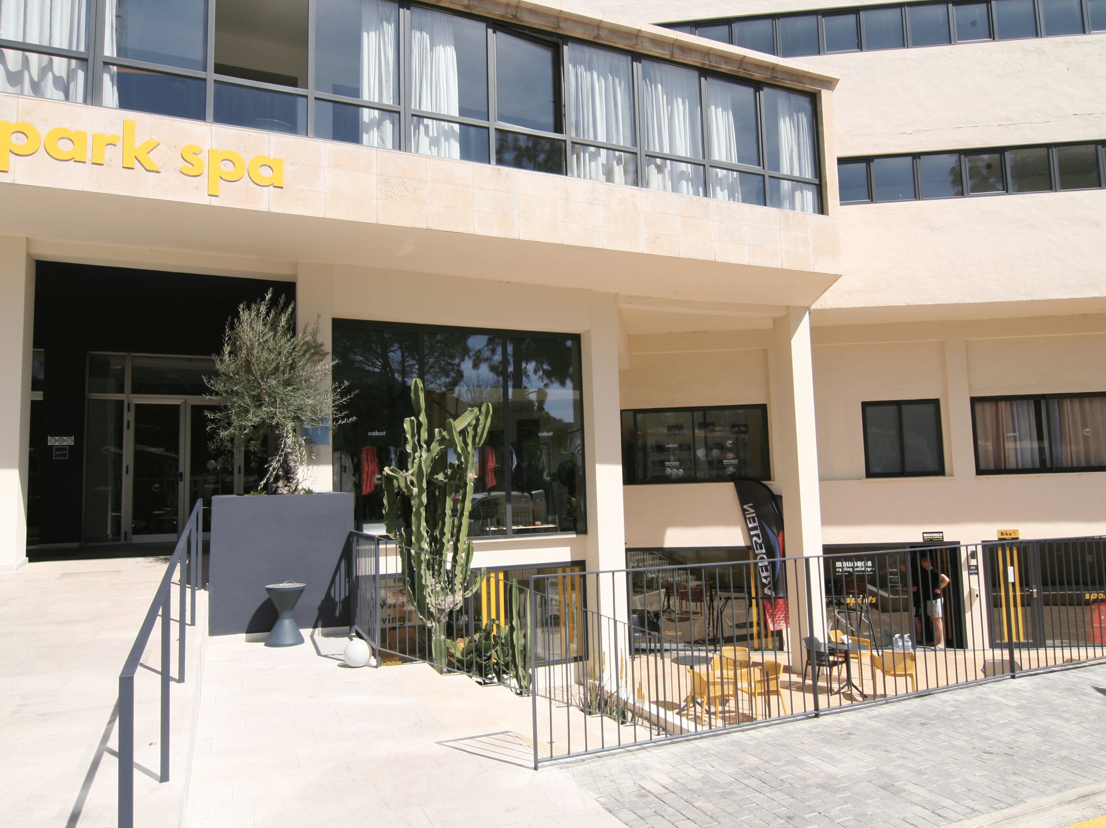 Un edificio con un letrero que dice 'park spa', asientos al aire libre y un patio amurallado.
