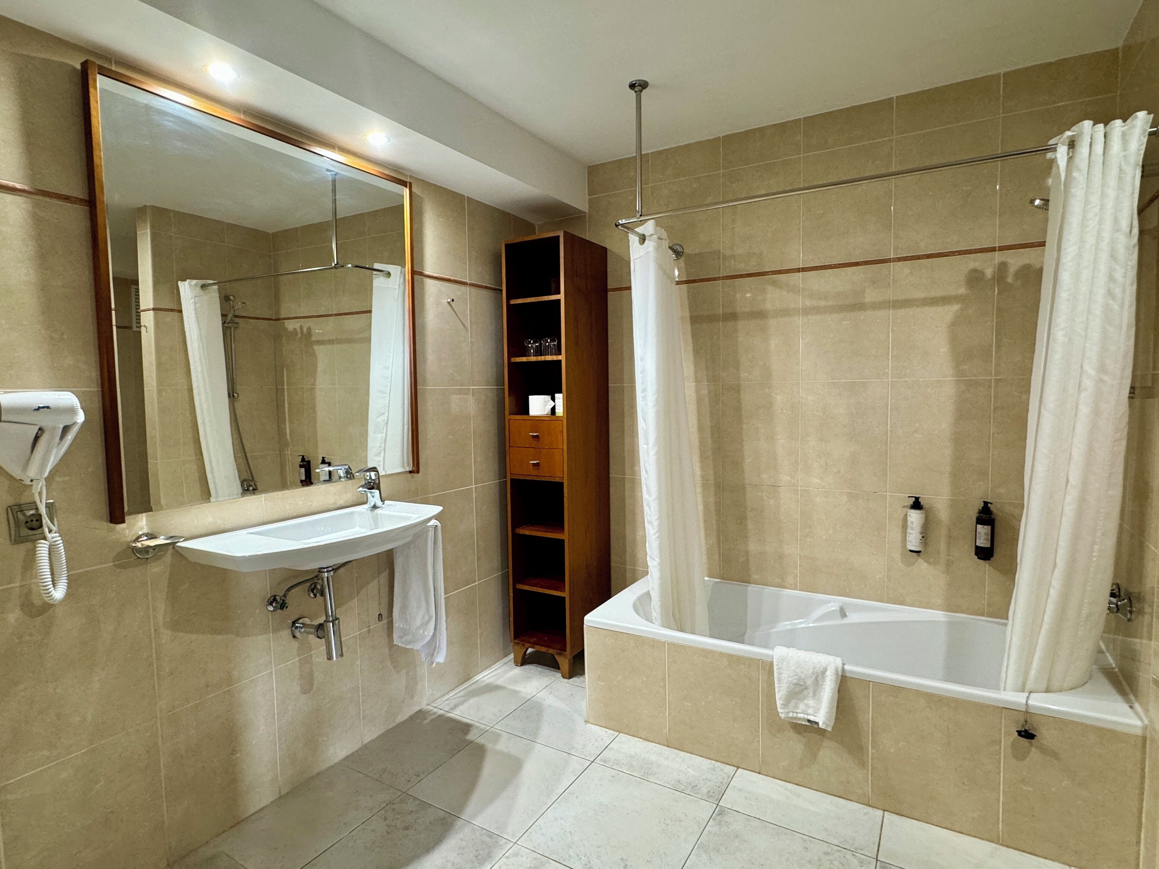 Un baño moderno con lavabo, espejo, ducha y bañera.