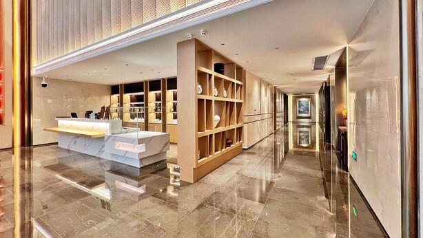 A modern hotel lobby with a reception desk, marble flooring, and a long corridor. - Landmark International Hotel (Guangzhou)
