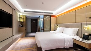 A modern hotel room with a large bed, bedside tables, a TV, and a walk-in closet. - Landmark International Hotel (Guangzhou)