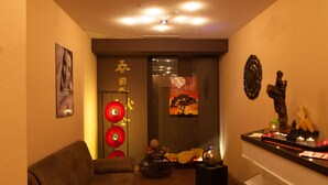 A warmly lit living area with a brown sofa, a decorative vase, and a small table with candles. - Best Western Aparthotel Birnbachhoehe (Bad Birnbach)