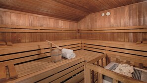 A sauna with wooden benches, a wooden bucket, and towels. - Best Western Aparthotel Birnbachhoehe (Bad Birnbach)