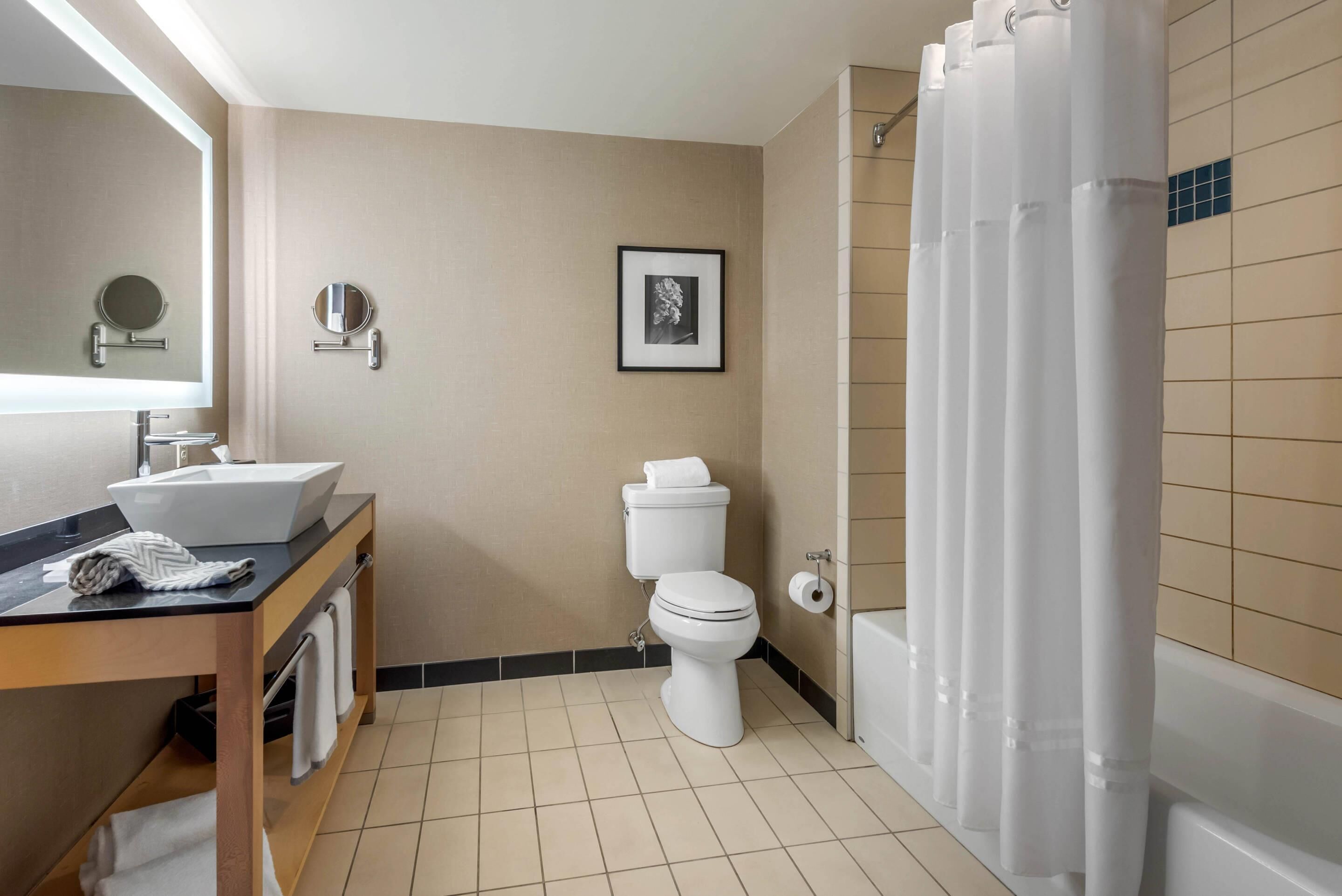 A bathroom with a sink, toilet, and shower curtain.