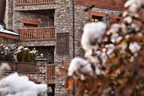 A stone building with a sign reading "HOTEL XX" and balconies with wooden railings. - Wuau! Hotel Segle XX (Ransol)