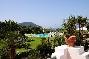Ein Poolbereich mit Liegestühlen und Blick auf einen Berg.