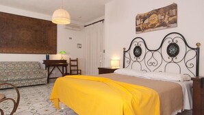Un dormitorio con una cama, un sofá, un escritorio y una silla.