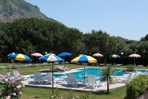 Una piscina techada, una piscina al aire libre de temporada, sombrillas