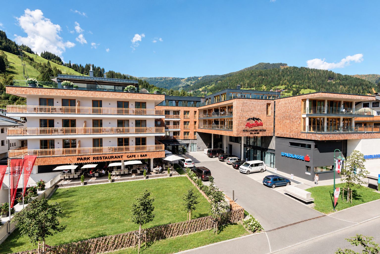 Een hotel met meerdere verdiepingen, terras buiten en uitzicht op de omliggende heuvels.