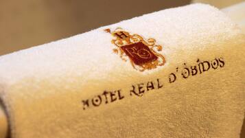 A towel with embroidered text and a crest, indicating a hotel setting.
