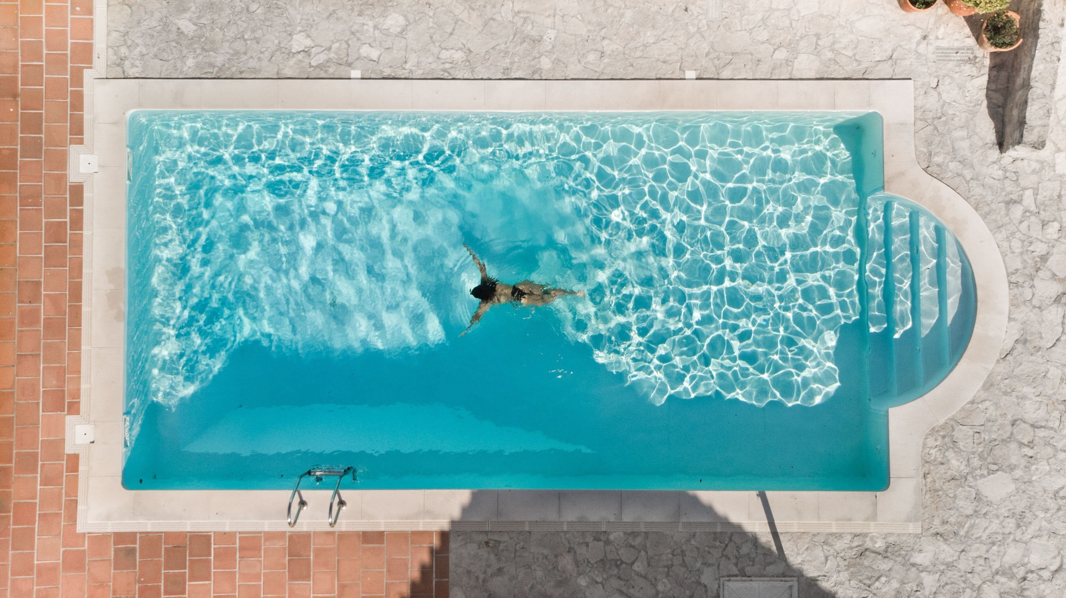 Una piscina al aire libre de temporada, sombrillas