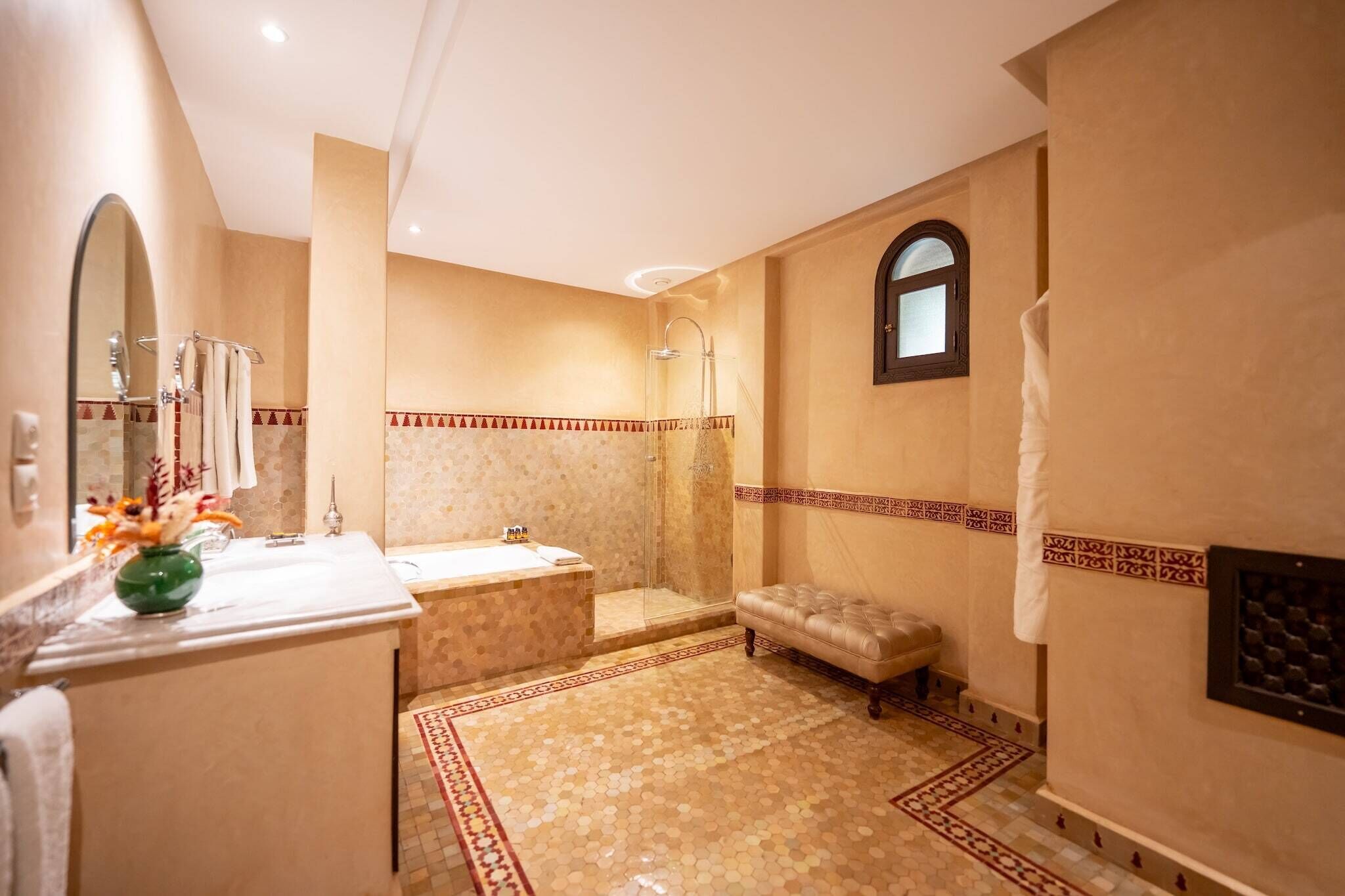 A bathroom with a bathtub, shower, and a vanity with a mirror.