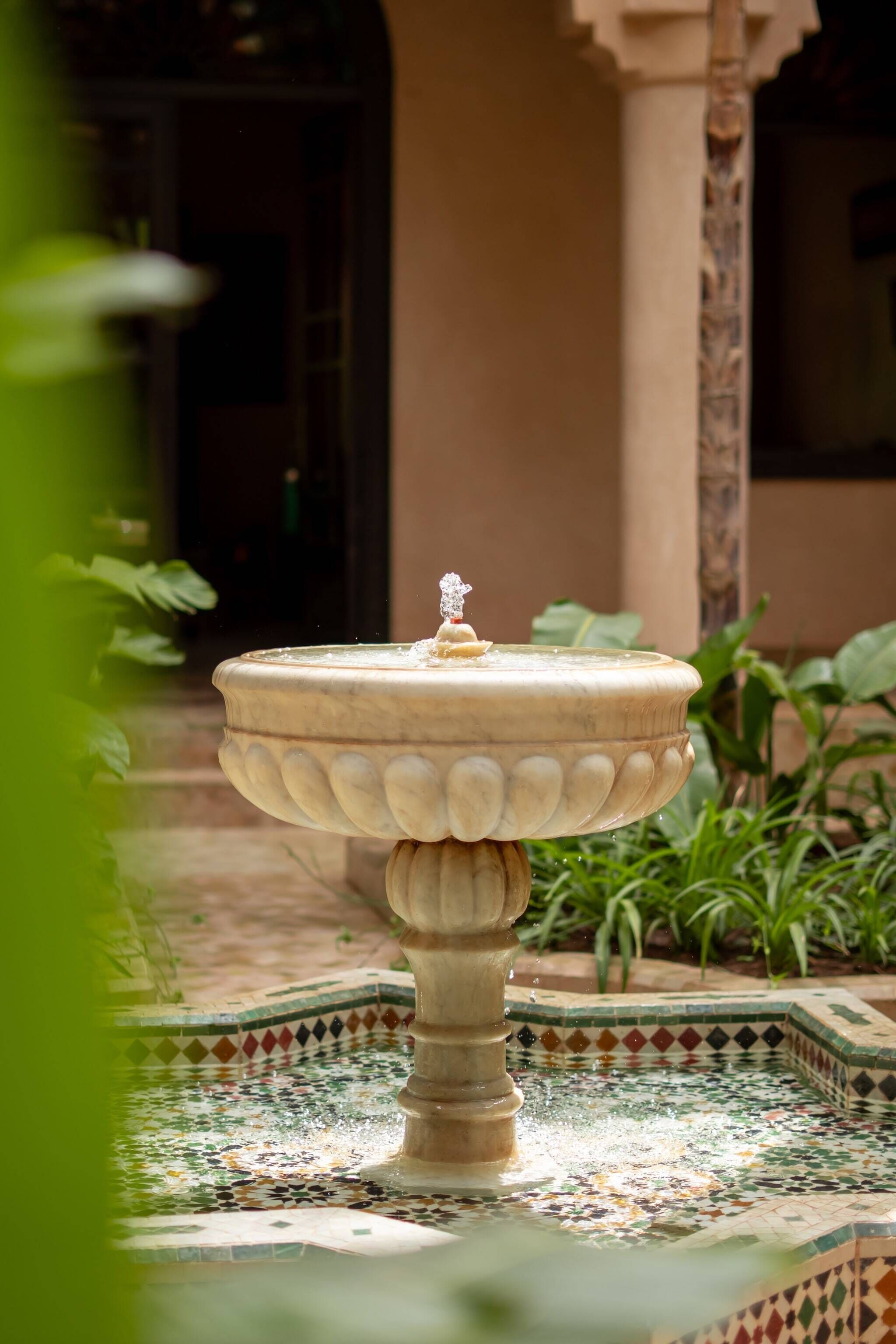 Una fuente con una base decorativa y una cuenca de azulejos.