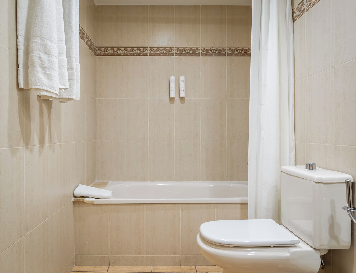 A bathroom with a bathtub, toilet, and towel rack.