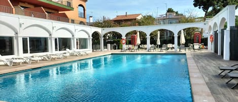 Piscine extérieure, parasols de plage, chaises longues