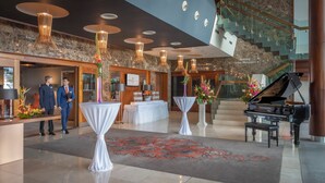 A hotel lobby with a grand piano, a reception desk, and a staircase. - Clayton Hotel Galway (Galway)