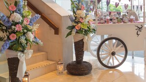 A modern interior with a staircase, a flower cart, and a cart with jars. - Clayton Hotel Galway (Galway)
