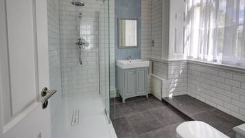 Un baño con ducha, lavabo e inodoro.