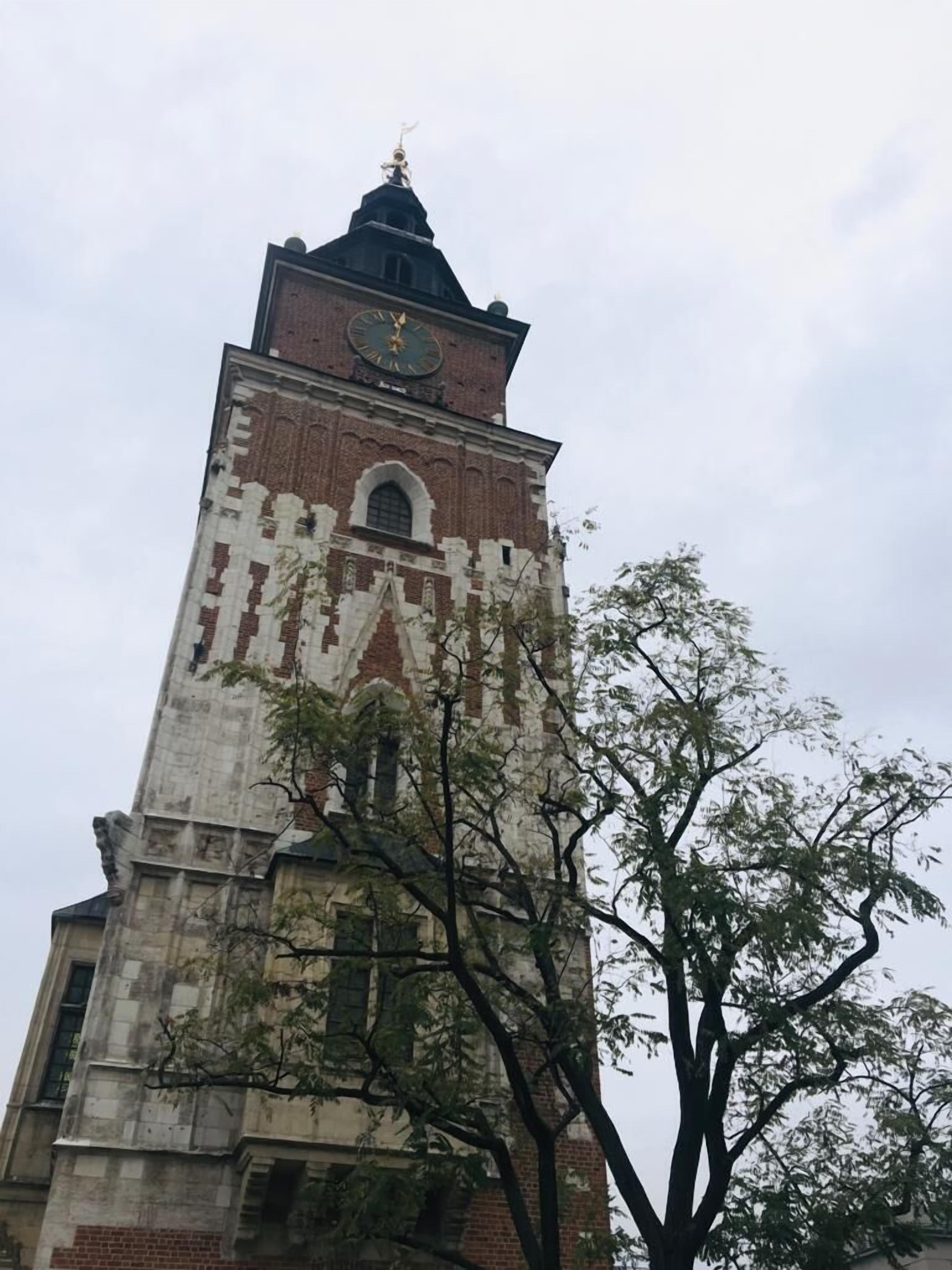 Korkea tiilestä rakennettu torni, jonka huipulla on kello.