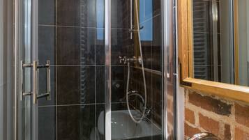 A bathroom with a glass-enclosed shower, a white sink, and a mirror.