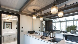 Eine moderne Küche mit einer großen Kochinsel, weißen Schränken und einem großen Fenster für viel Tageslicht.
