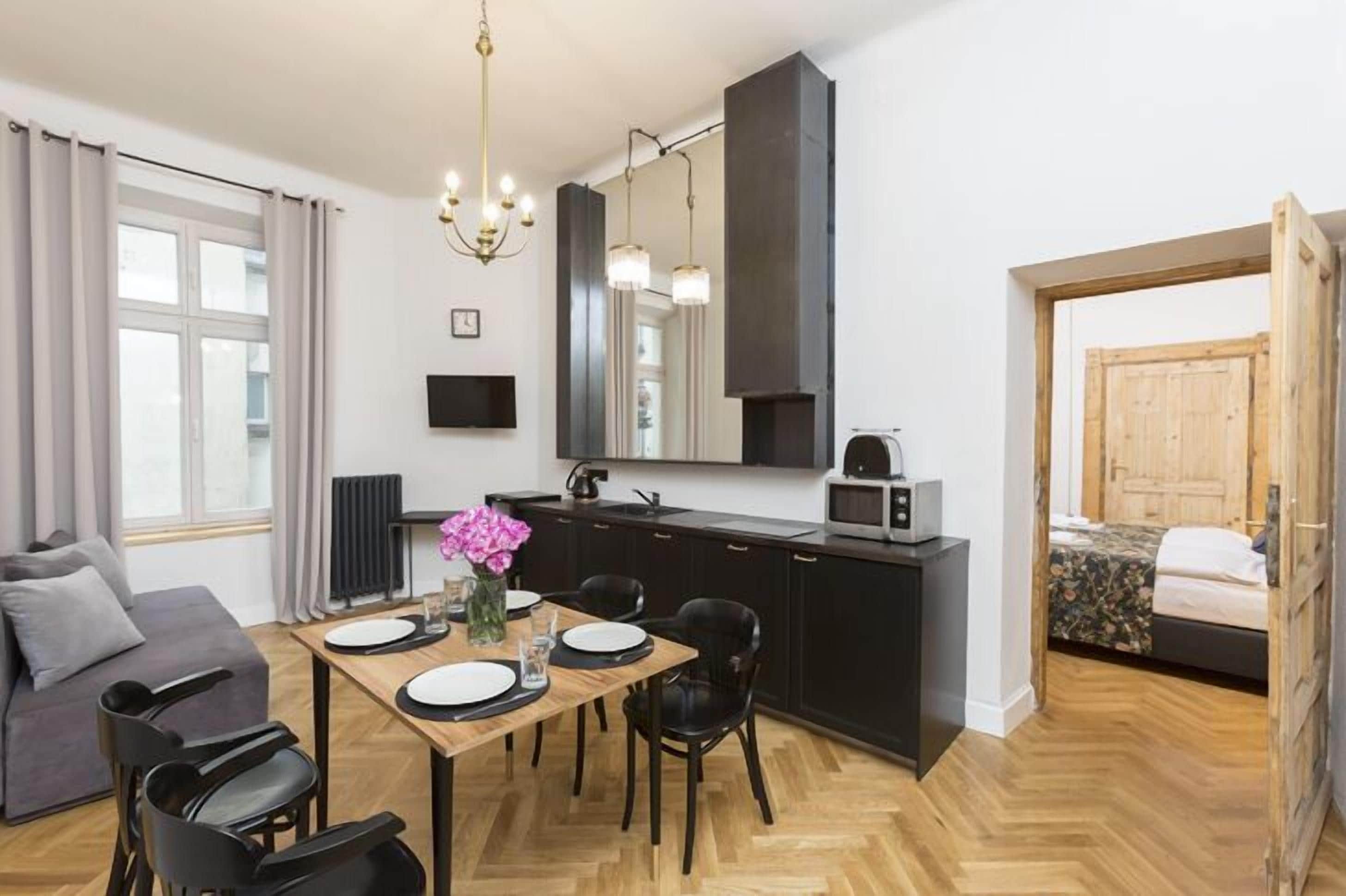 Un espacio habitable compacto con kitchenette, comedor y cama.