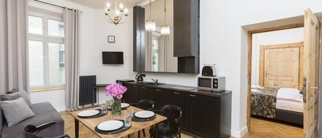 Un espacio habitable compacto con kitchenette, comedor y cama.