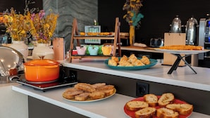 A breakfast buffet with various pastries, bread, and a hot pot on a modern kitchen counter. - HF Fénix Garden (Lisbon)