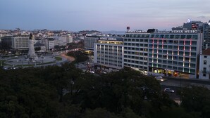 A hotel with multiple floors, a prominent entrance, and a view of the surrounding cityscape. - HF Fénix Garden (Lisbon)