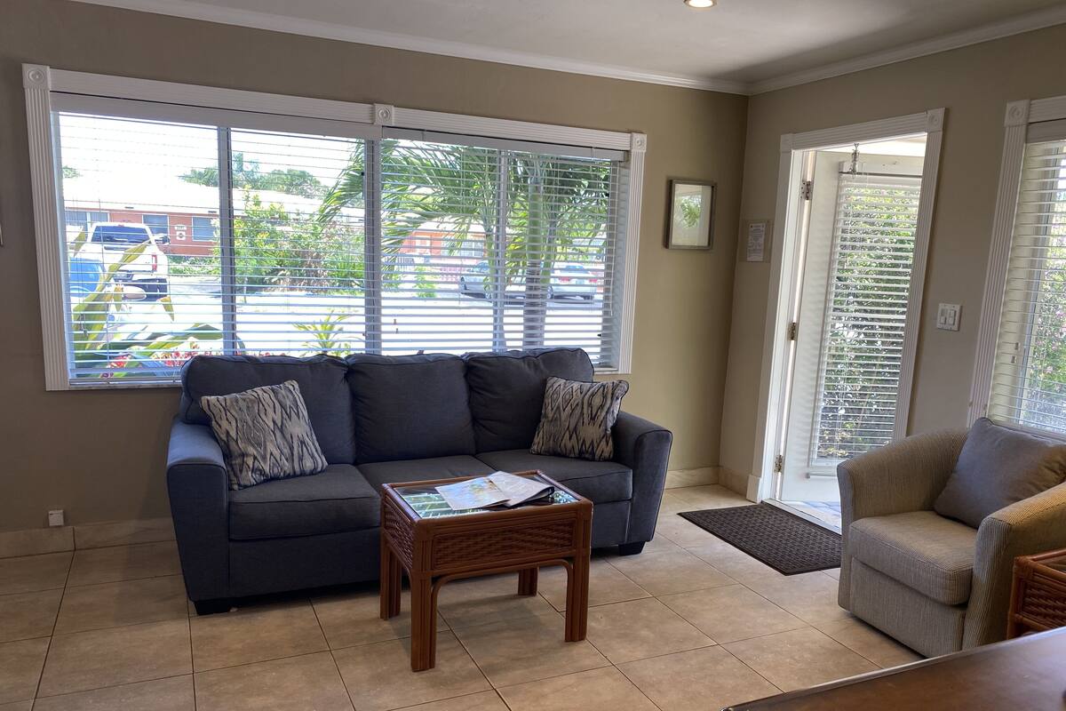 A living room with a dark grey sofa, a wooden coffee table, and a light grey armchair.