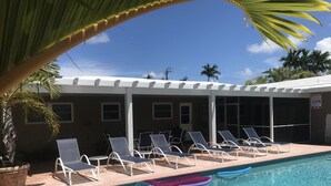 A pool area with lounge chairs, a pool, and a covered structure. - Casitas Coral Ridge (Fort Lauderdale)