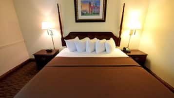 A hotel room with a large bed, two bedside tables with lamps, and a framed picture on the wall.