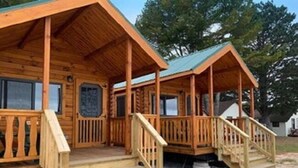 A wooden cabin with a porch and steps leading to the entrance. - Waterfront Inn - Mackinaw City (Mackinaw City)