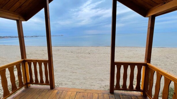 A wooden beach pavilion with a view of the beach and ocean. - Waterfront Inn - Mackinaw City (Mackinaw City)