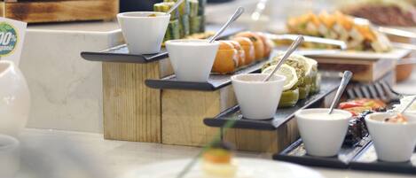 A buffet with various food items and condiments.