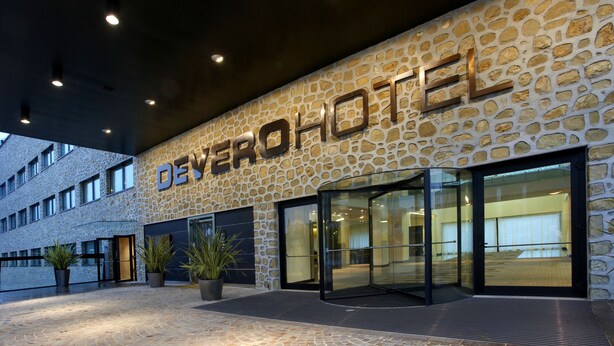 A hotel exterior with a stone facade and a glass entrance. - Devero Hotel & Spa, BW Signature Collection (Cavenago di Brianza)