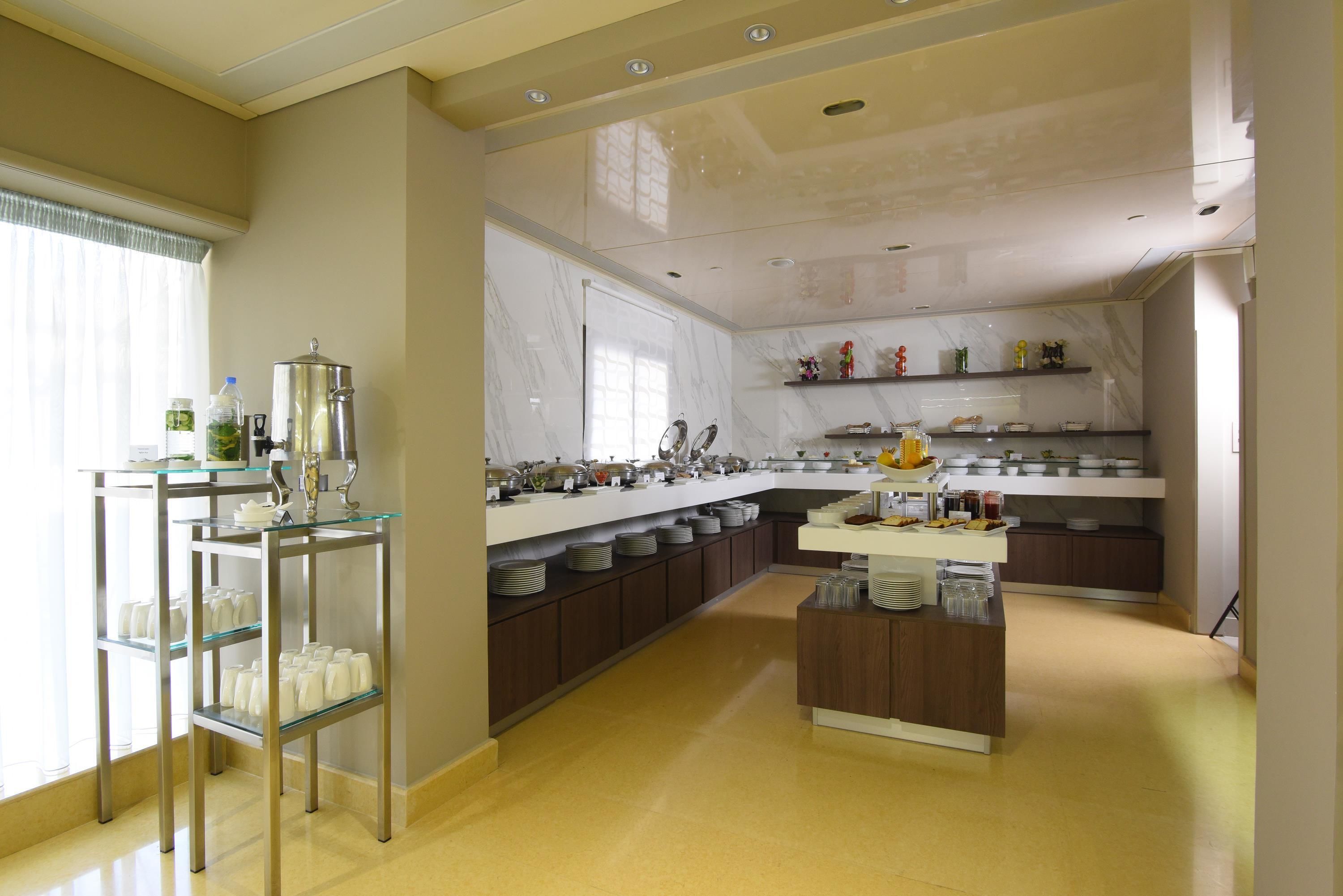 A modern kitchen with a marble countertop, stainless steel appliances, and a glass display unit.