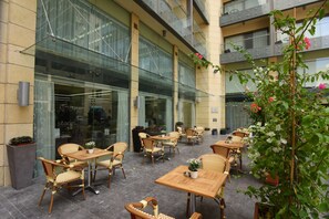 An outdoor seating area with wicker furniture and potted plants. - Ramada by Wyndham Downtown Beirut (Beirut)