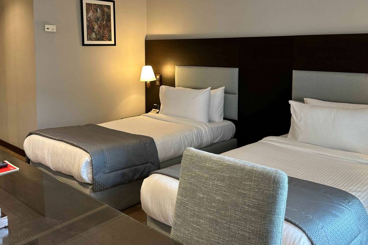 Una habitación de hotel con dos camas, un escritorio y una silla.