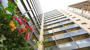 Un edificio de gran altura con un diseño arquitectónico moderno, que cuenta con varias terrazas y ventanas amplias.