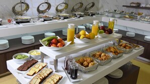 Un bufé con una variedad de alimentos, entre ellos frutas, pasteles y bebidas.